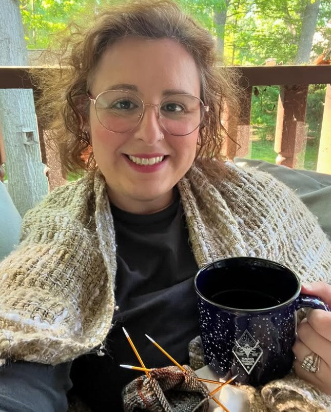 Sarah Mae knitting and drinking coffee.